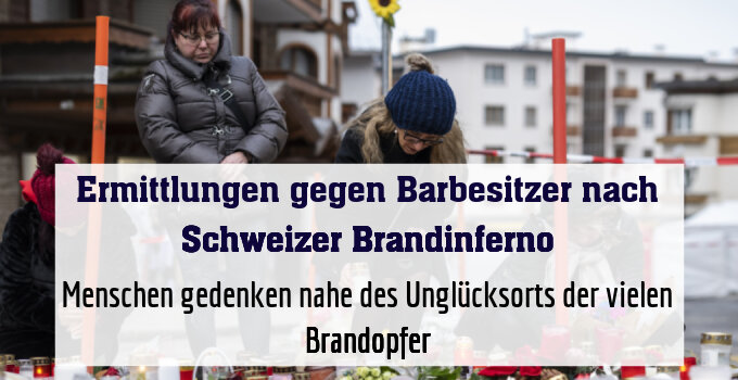 Menschen gedenken nahe des Unglücksorts der vielen Brandopfer