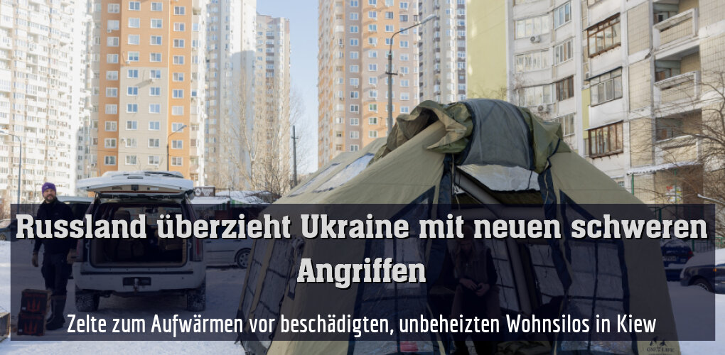 Zelte zum Aufwärmen vor beschädigten, unbeheizten Wohnsilos in Kiew
