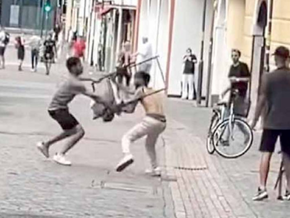 Zwei junge Männer prügeln sich mit Klappstühlen