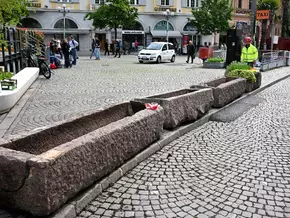 Blumenkästen aus Porphyr statt New-Jersey-Betonbarrieren