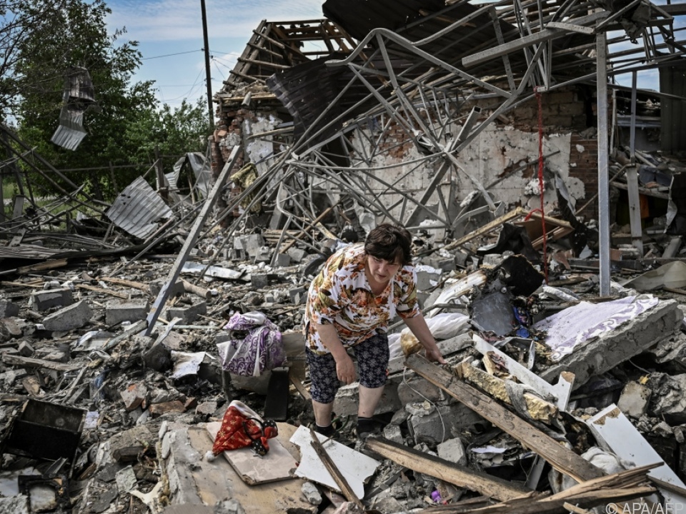 Ukrainerinnen durchsuchen die Trümmer ihrer Häuser