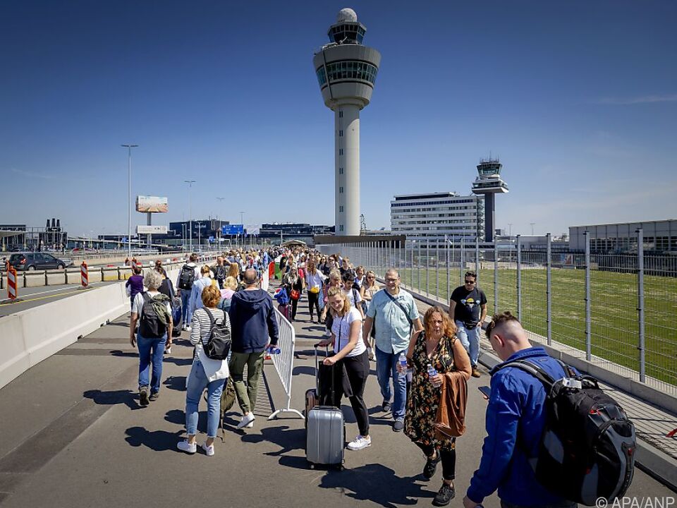 Vor der Abflughalle wartende Reisende am Flughafen Schiphol am Freitag