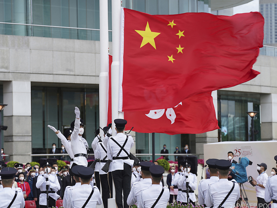 Chinas Flagge weht neben der Fahen Hongkongs