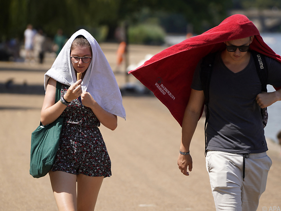 Passanten im Londoner Hyde Park suchen Schutz vor der Sonne