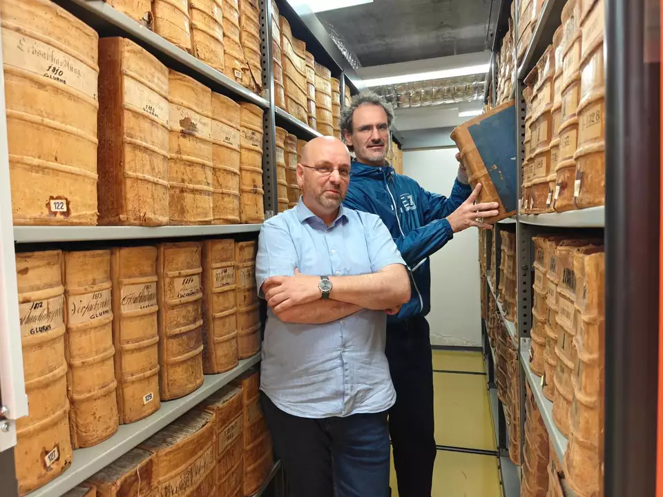 Gustav Pfeifer, der Direktor des Landesarchivs (im Bild vorne), und sein Mitarbeiter Philipp Tolloi mit den historischen Archivbeständen. Heute werden die meisten digitalen Unterlagen, die auf Dauer verwahrt werden sollen, über den Dienst ParER digital archiviert.